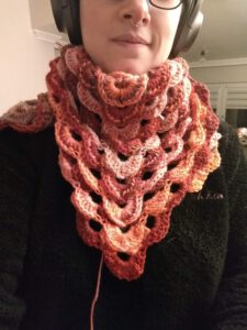 leaf-inspired crochet project in progress, wrapped around the maker's neck