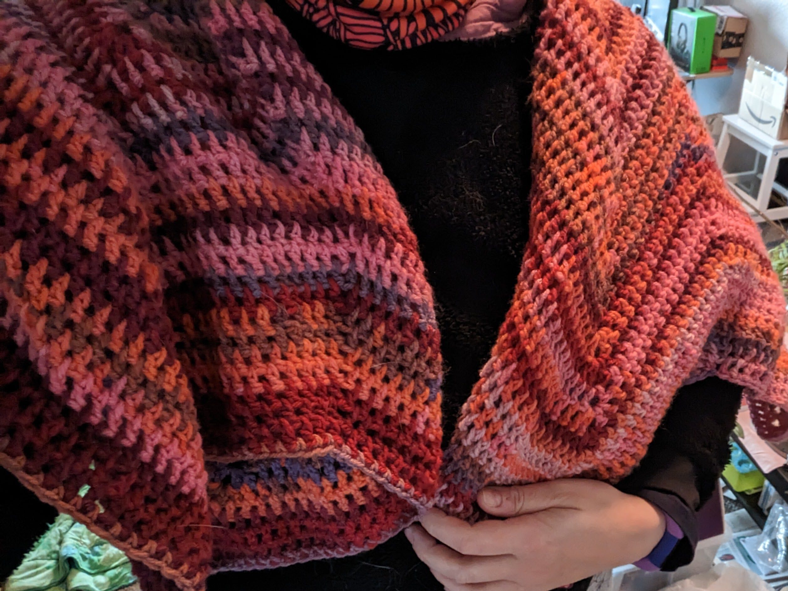 afghan wrapped around the maker's shoulders